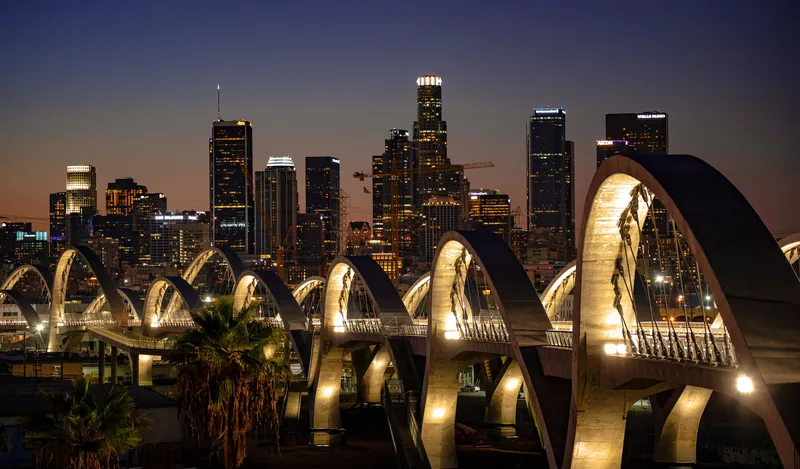 Stunning view of the illuminated Sixth Street Bridge with Los Angeles skyline at night.