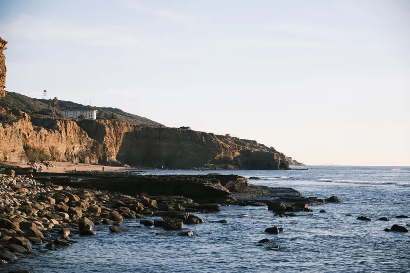 Scenic view of ocean waves hitting rocky shoreline with imposing cliffs