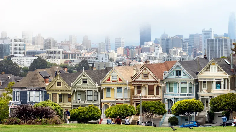 Iconic view of Painted Ladies with San Francisco skyline in the background. A classic urban scene.
