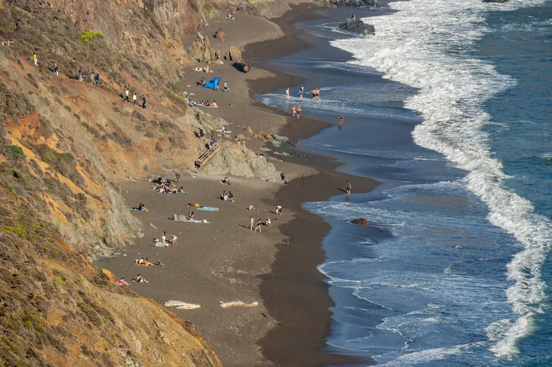 Aerial view of a picturesque beach with people enjoying the sun and waves.
