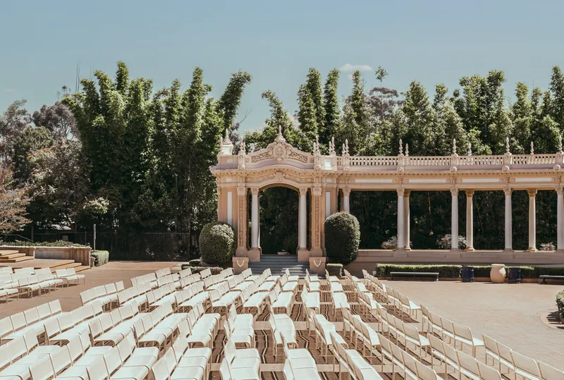Elegant outdoor theater with rows of white chairs in San Diego's lush green surroundings.