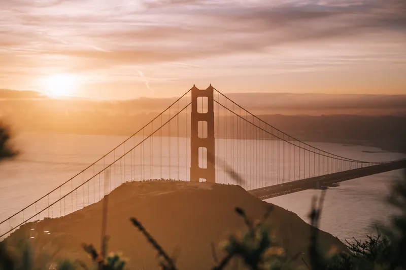 Stunning sunrise view of Golden Gate Bridge in San Francisco, capturing the iconic landmark with a warm glow.