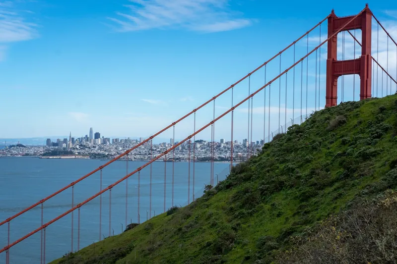 A scenic view of the Golden Gate Bridge with San Francisco skyline in the background.