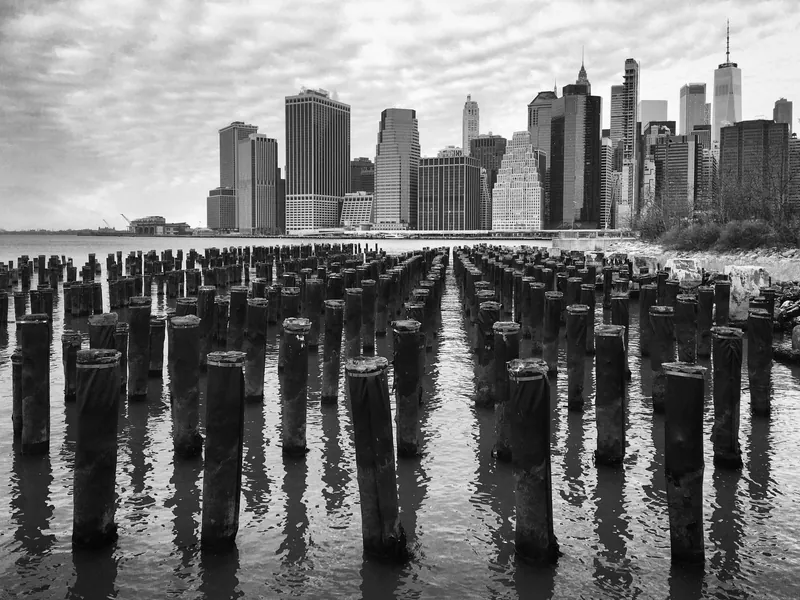 Striking black and white image of the Manhattan skyline photographed from Brooklyn's waterfront.
