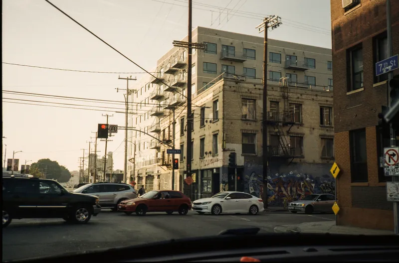 Busy intersection in a city with cars and urban buildings during the day.