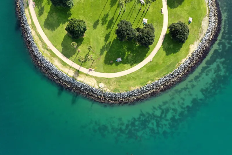 Stunning aerial view of a circular park by the ocean in San Diego, showcasing lush greenery and clear waters.