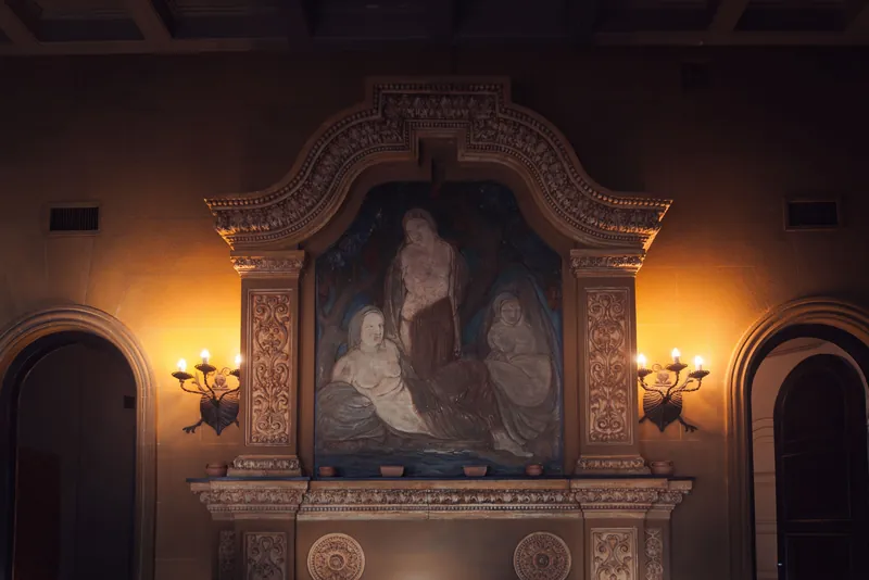 Elegant interior showcasing a vintage wall mural and antique lighting in a historic setting.