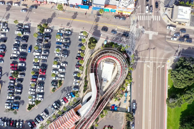 Aerial view of a parking lot, roads, and a unique curved structure in San Diego.