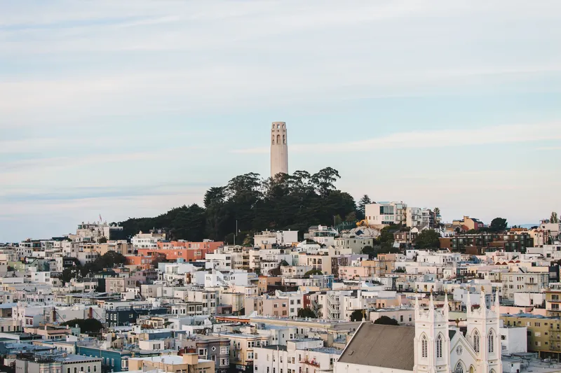 A view of Coit Tower overlooking the rooftops of San Francisco, showcasing urban architecture.