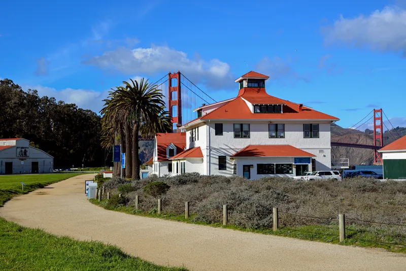 A scenic view of the Presidio building with the Golden Gate Bridge in the background on a clear day in San Francisco.