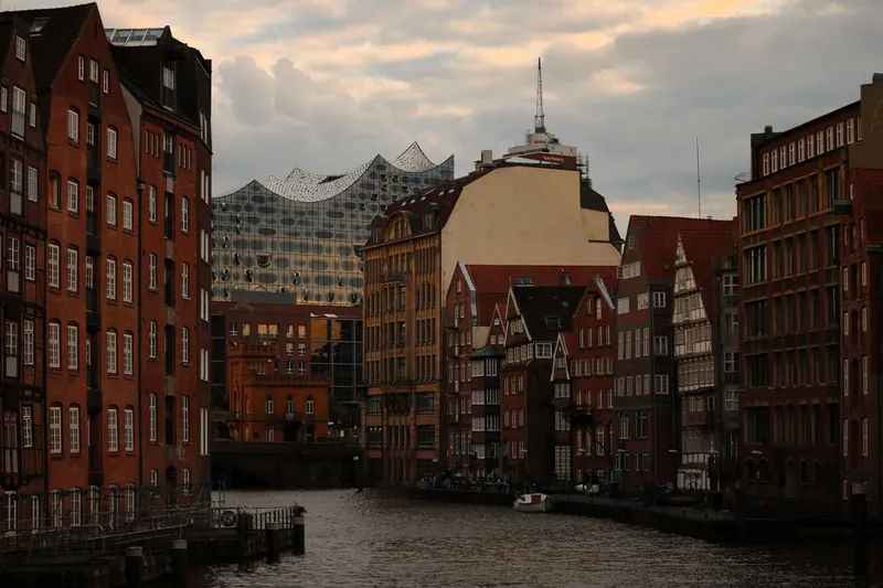 Evening view of historic Hamburg buildings with the Elbphilharmonie in the background.