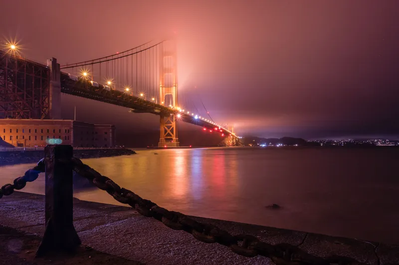 Stunning long exposure shot of the Golden Gate Bridge illuminated at night in San Francisco, California.