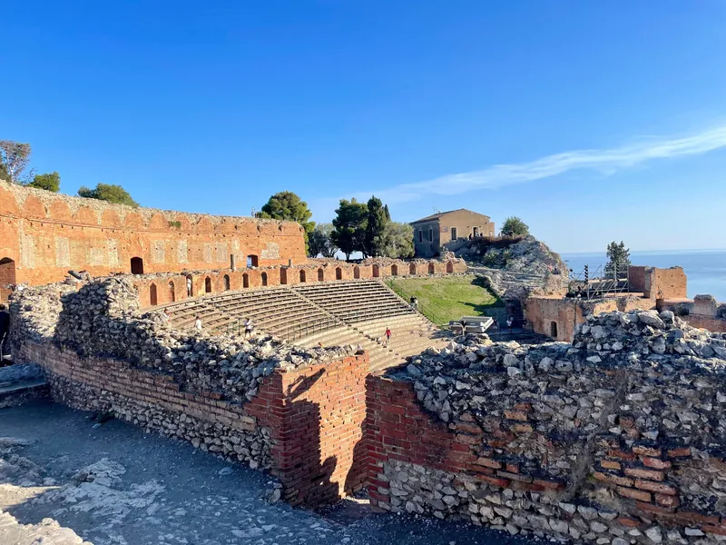 Explore the ancient Greek Theatre in Taormina, Sicily with stunning Mediterranean views.