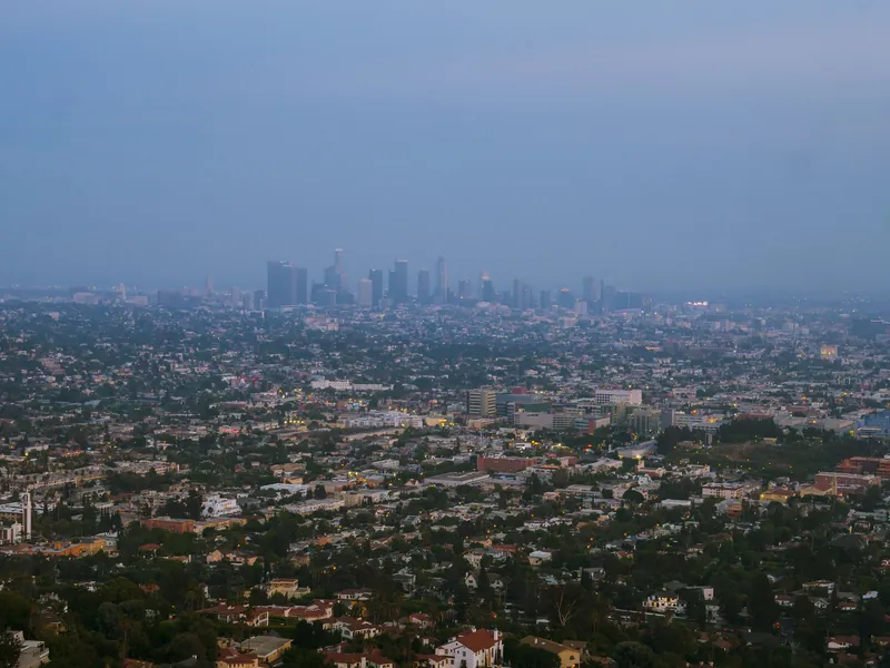 Aerial view of downtown Los Angeles cityscape at twilight, showcasing urban skyline and city lights.