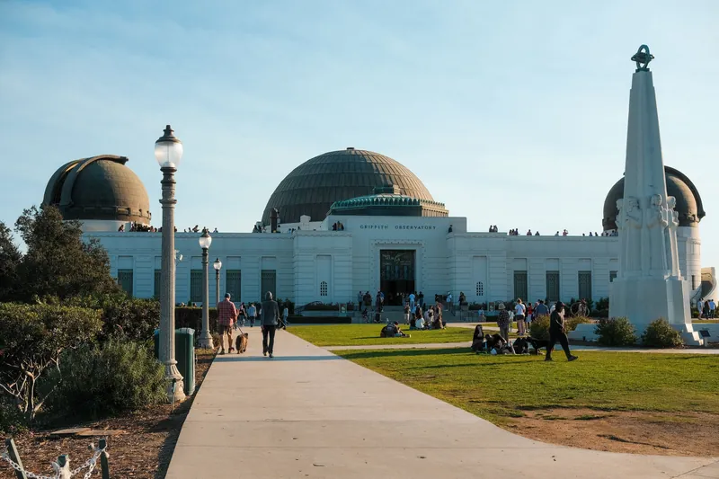 Griffith Observatory in Los Angeles on a sunny day with visitors enjoying the landmark.
