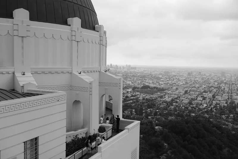 A scenic view from Griffith Observatory with Los Angeles skyline in the background.