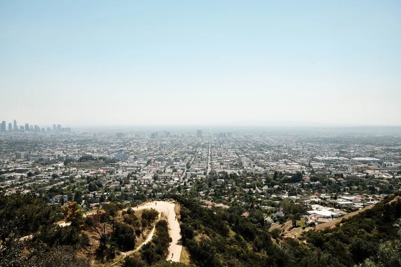Aerial view of Los Angeles skyline featuring downtown and surrounding cityscape from Griffith Park.