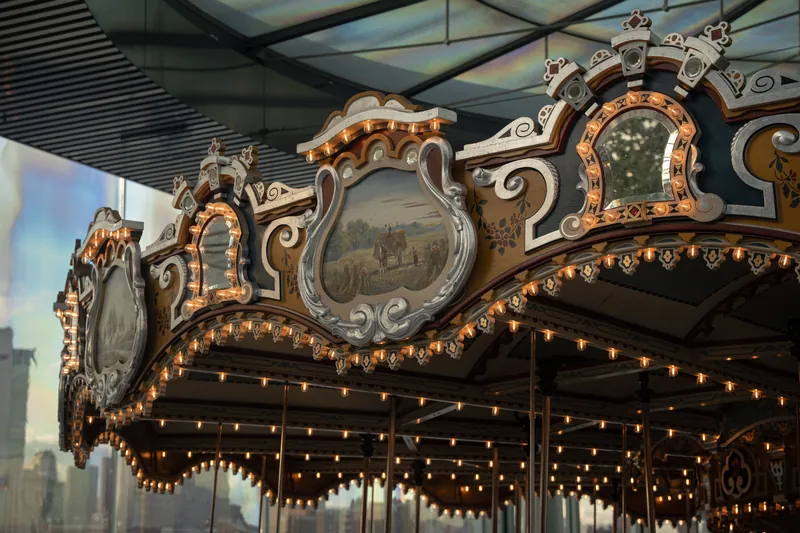 Close-up of Jane's Carousel with ornate decorations and lights in New York City.