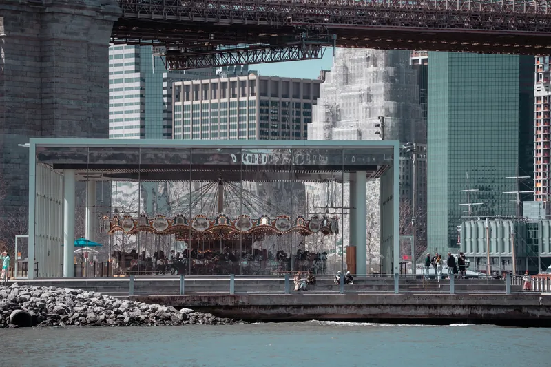 A carousel sits beneath the brooklyn bridge