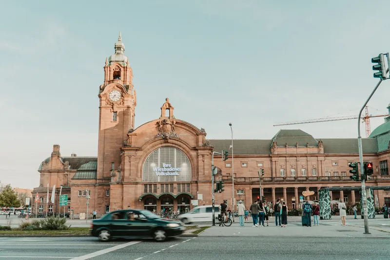 View of Wiesbaden's historic railway station with clock tower, showcasing classic architectural design.