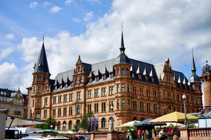 Historic Gothic Revival building under a bright sky in Wiesbaden, Germany showcasing urban architecture.