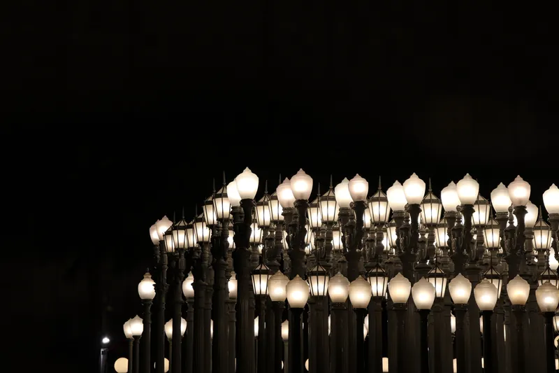 A series of vintage street lamps at LACMA in Los Angeles, captured at night.