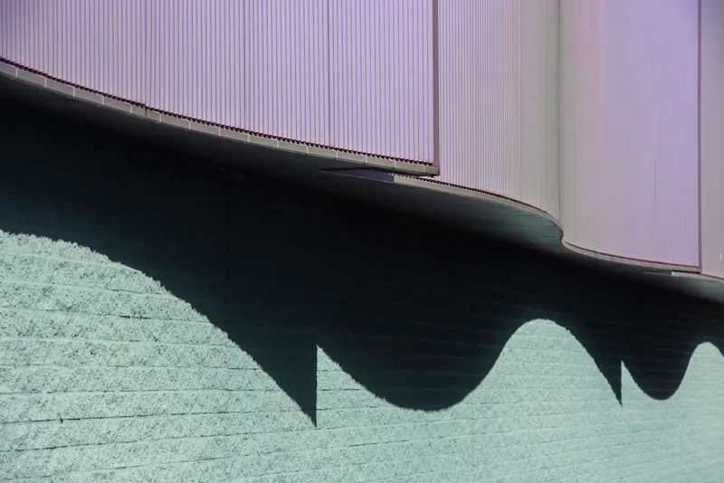 Abstract photo of architectural shadows on a textured wall with a curved facade.
