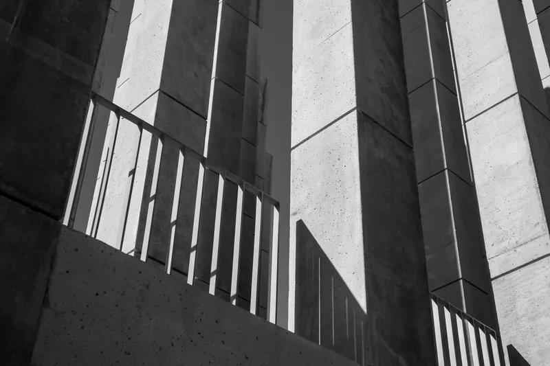 Abstract black and white image capturing shadows on concrete architectural structure.
