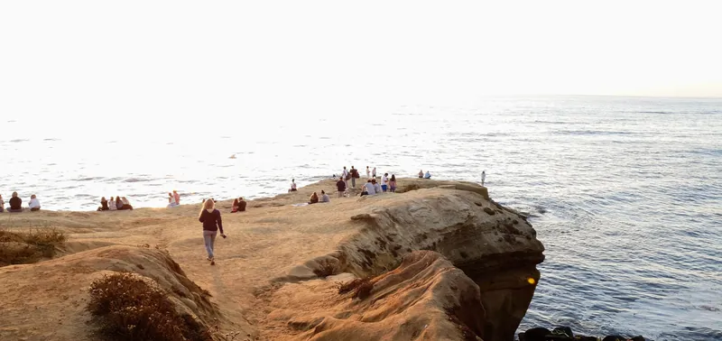 A serene evening at Sunset Cliffs, San Diego with people enjoying the coastal view.