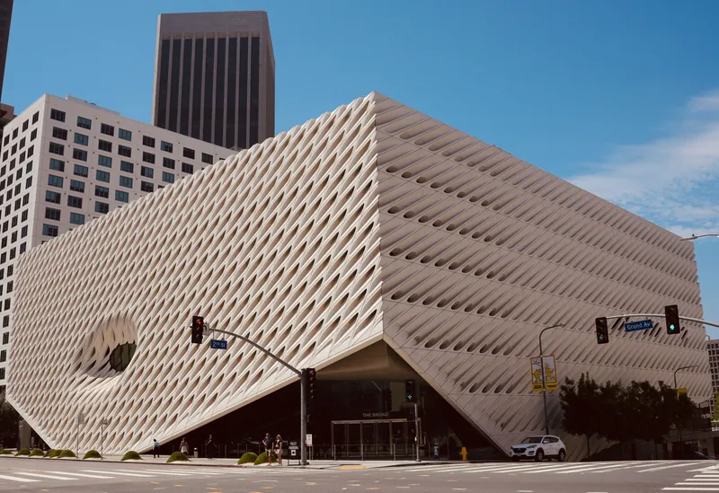 Modern architectural shot of The Broad Museum in Los Angeles under a clear blue sky.