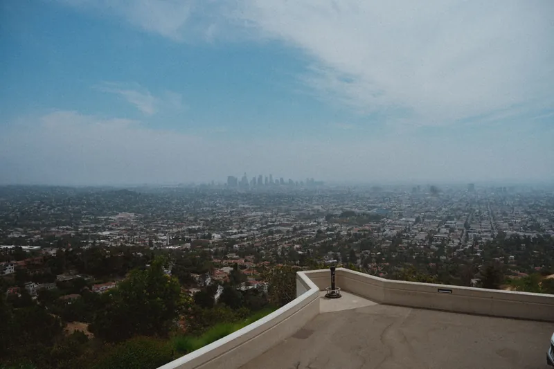 Beautiful panoramic view of Los Angeles cityscape from Griffith Observatory under a clear blue sky.