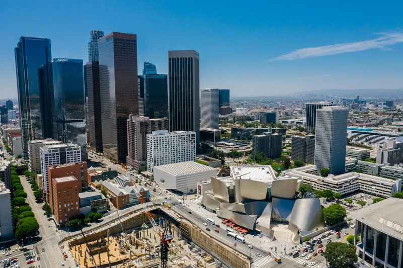 Aerial view of downtown Los Angeles featuring the iconic Walt Disney Concert Hall on a clear day.