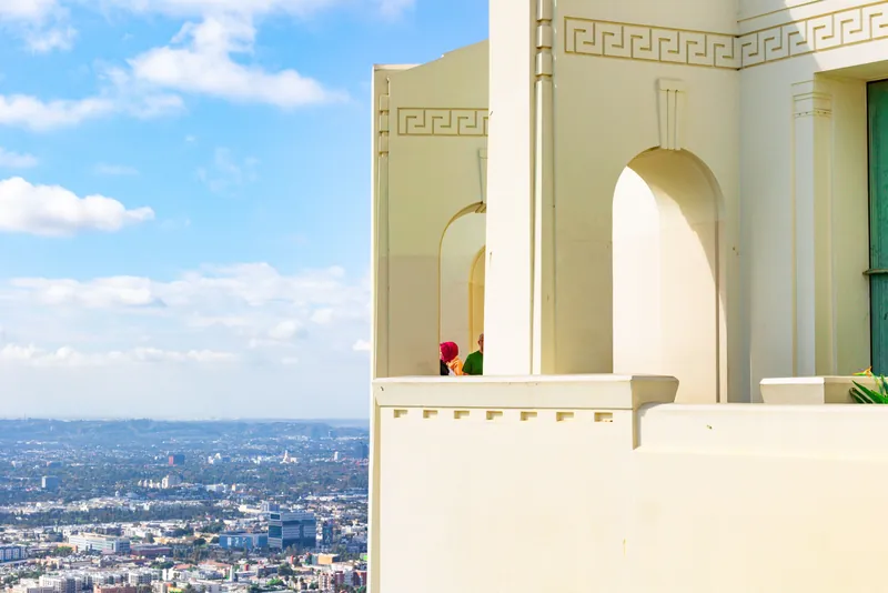 View of Griffith Observatory with Los Angeles skyline under a clear sky.