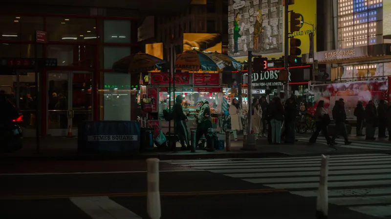 Street food vendor at Times Square, NYC, capturing the bustling nighttime atmosphere.