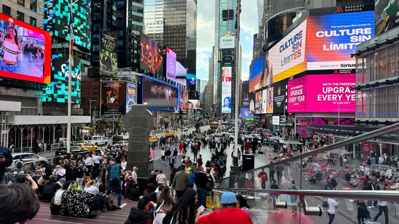 Dynamic scene in Times Square, New York City with colorful billboards and diverse crowd.
