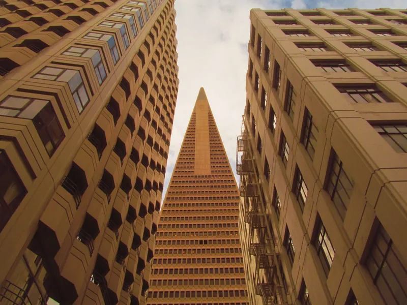 A striking view of the Transamerica Pyramid framed by adjacent buildings in San Francisco.