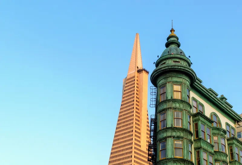 View of the Transamerica Pyramid and Sentinel Building in San Francisco under clear blue sky.