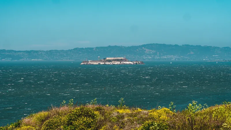 Picturesque view of Alcatraz Island surrounded by San Francisco Bay under clear sky.