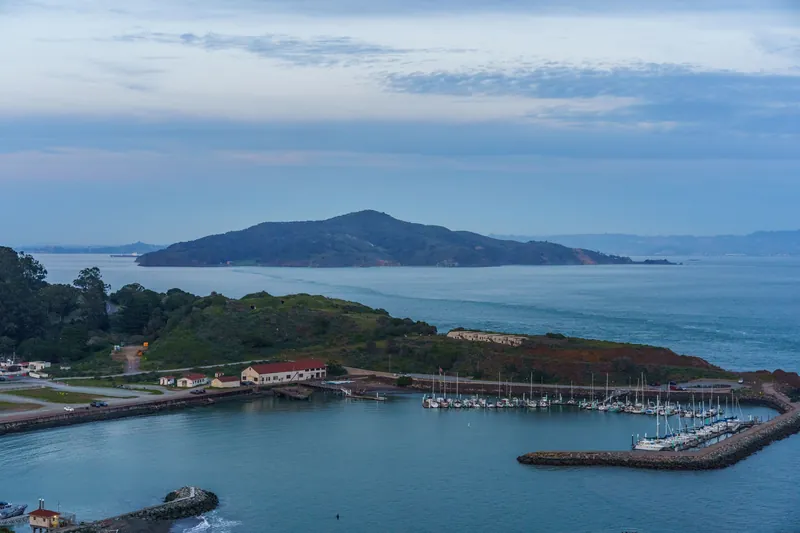 Beautiful aerial view of a marina by a lush green coastline at dusk.