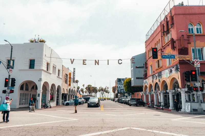 Street view of Venice Beach in Los Angeles, California featuring colorful buildings and lively atmosphere.